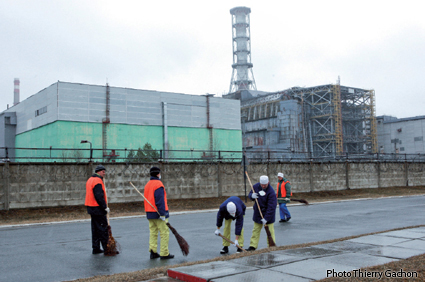 Photo d'ouvriers nettoyant les abords de la centrale.