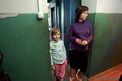 Photo de Katia et sa maman sur le seuil de la porte de leur logement.
